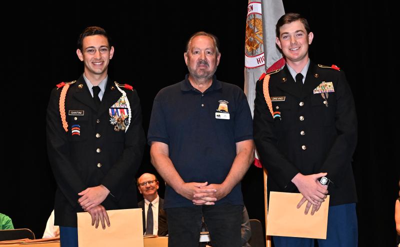 Col. Jeff Schellenger of the Order of the Dandelion Medal presents awards to Lucas Santini, left, and Liam Drevno.