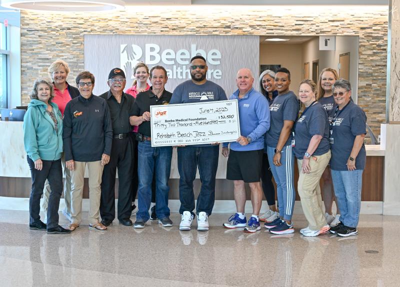 The Rehoboth Beach-based Delaware Celebration of Jazz presents a $32,500 check to the Beebe Medical Foundation before the Miracle Mile walk. Shown are (l-r) Kas Naylor, board member, DCJ; Kay Young, executive director of development, Beebe Medical Foundation; Larry DeFrancisco, vice president of the DCJ; Bing Crosby, board member, DCJ; Stephanie Adams, gift officer, Beebe Medical Foundation; Denny Santangini, president of the DCJ; Maurice Winkfield, executive director, Beebe Oncology Services; Tom Protack, president of Beebe Medical Foundation; Rita Williams, manager, Beebe Oncology Psychosocial and Integrative Health Services; Alexia Hines, radiation manager, Beebe Healthcare Oncology Services; Karen Long, operations manager, Beebe Oncology Services; Colleen Glasco, nurse manager, Beebe Oncology Services; and Doreen DiLorenzo, manager, Beebe Oncology Business Services.