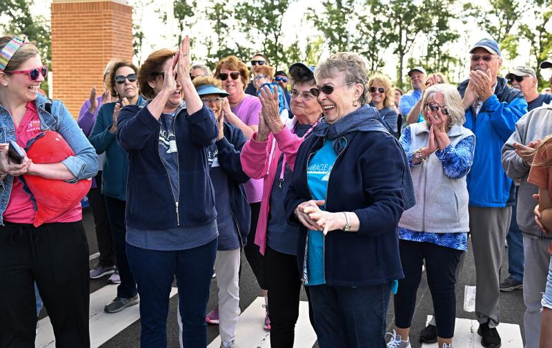The group gathered to walk gives a round of applause to Arline Simpson, founder of the Miracle Mile walk.
