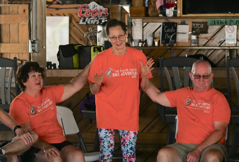 Michele Williams, Lewes cycling and affordable housing advocate, receives assurances from Fuller Center cyclists Cindy and Dan Hepp as they meet in a circle.