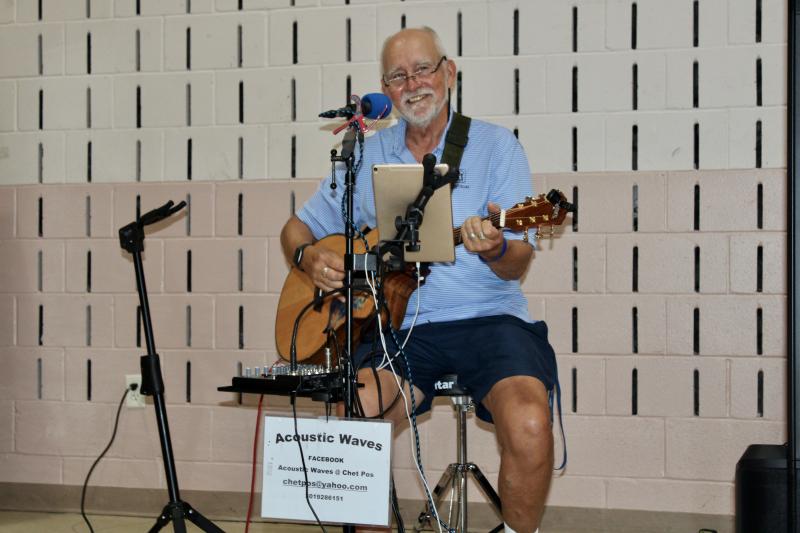 Chet Poslusny of Acoustic Waves plays his guitar as international students enjoy dinners prepared by Epworth United Methodist Church and desserts made by Seaside Jewish Community.