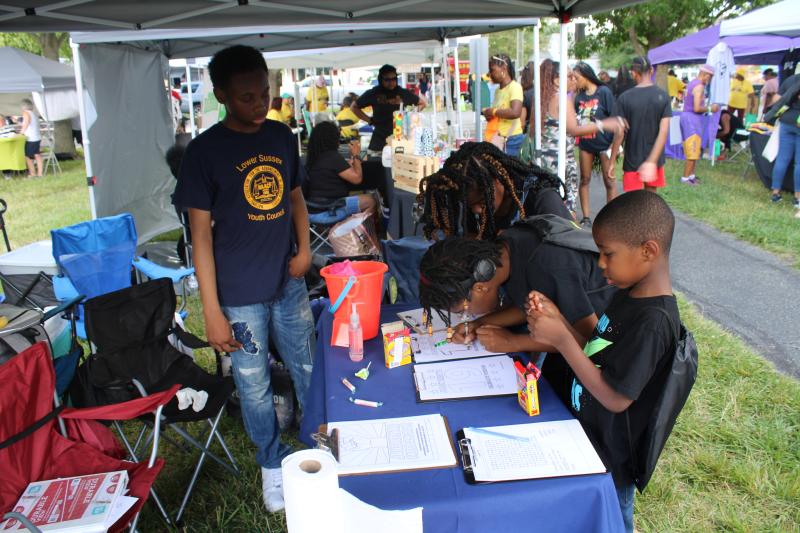 Shamir Lambert, vice president of the Lower Sussex Association of Colored People Youth Council, oversees the artwork of the Coleman kids. Shown are (l-r) Lambert and Jasmine, Taylor, and Brandon Coleman.
