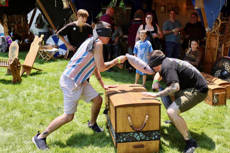 Klan Runda of Boone, N.C., brought a few Viking games for people of all ages to enjoy. In this fish-slapping game, one must keep their hand on the table throughout the game and must get permission from the other person to slap them with their fish. Slappers follow the sound of their opponent’s voice. Shown is Ken Ayer receiving a point from official Jadent Buchholz of Klan Runda for striking his opponent Dan Newman. AARON MUSHRUSH PHOTO