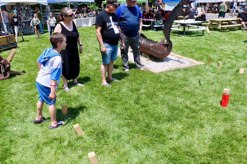 Brendan Water, 7, of Newark tosses a wooden peg over to his opponent's boundary during a Viking lawn game. AARON MUSHRUSH PHOTO