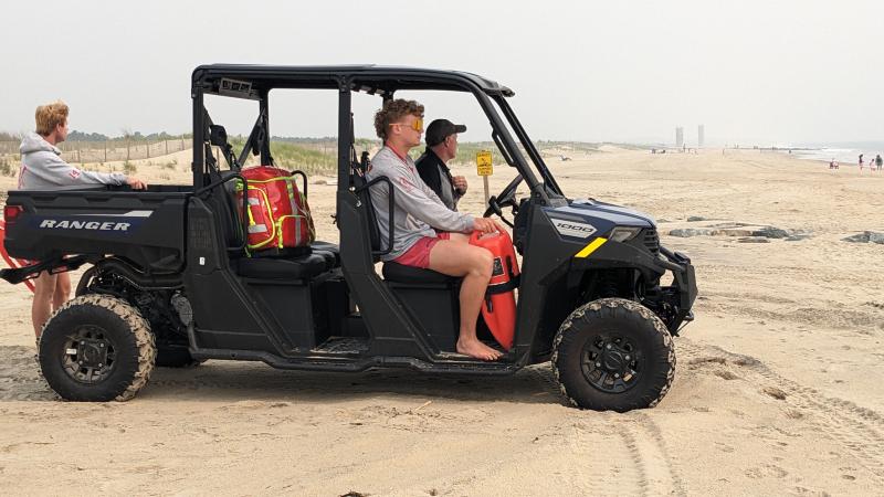 North Shores lifeguards reduced their patrol for June 8 due to unhealthy air quality. Air quality June 8 was reached 221 for the Delaware beaches, meaning the air is at unhealthy levels. Shown here are Augie Carlozzi, standing, and Gabe Poad patrolling the water from an ATV driven by Chip Hannig. Hannig says the towers in the background are usually clearly visible. AARON MUSHRUSH PHOTO