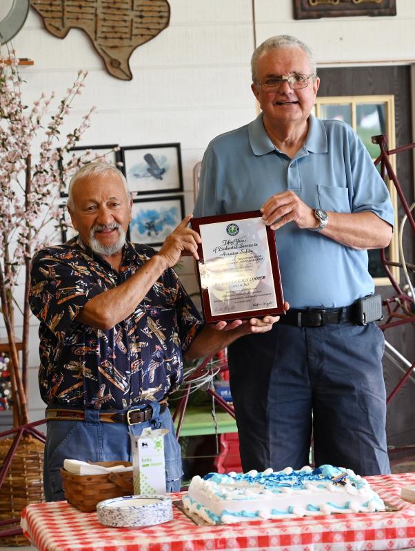 Friend and fellow pilot John Chirtea, left, hands the Wright Brothers Master Pilot Award to Bob Cooper. Chirtea received the same award in 2019.