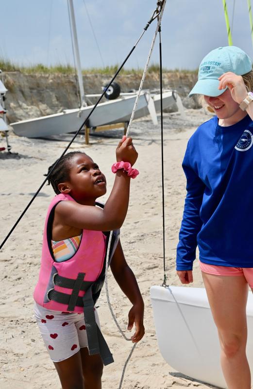 Under the watchful eye of LYC sailing instructor Tatum Carney, Jakari Hazzard grabs a line to hoist the sail to get ready for an afternoon of sailing on Delaware Bay.