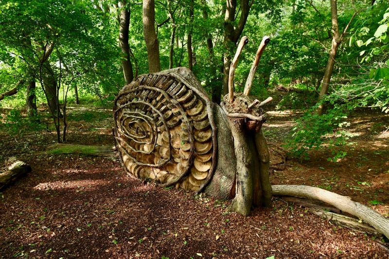 The 12-acre Woodlands includes handicap-accessible walking trails, volunteer-made wooden creatures like this large snail, and native plants. The area slopes to the 1,000-foot shoreline along Pepper Creek.