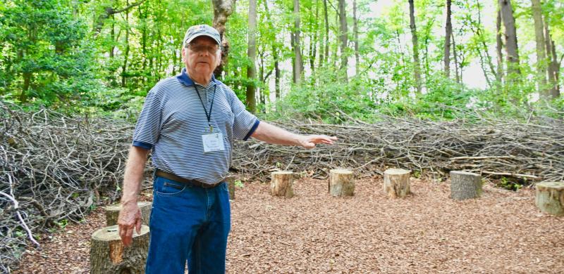 Board member and Vice President Brent Baker explains how the large birds nests in the Woodland are built, using broken and trimmed limbs from the forest. Some of the areas are used as outdoor classrooms.