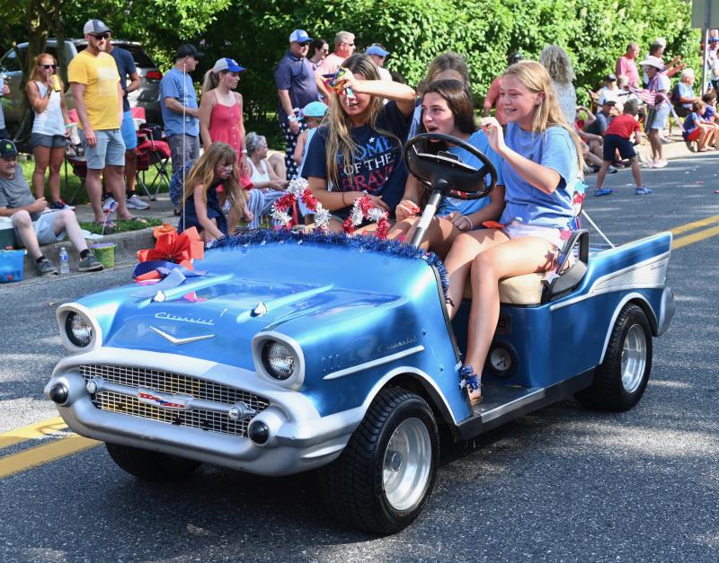 How many young girls can you stuff in a mini Chevrolet car? How about four, as they have fun taking part in the parade.