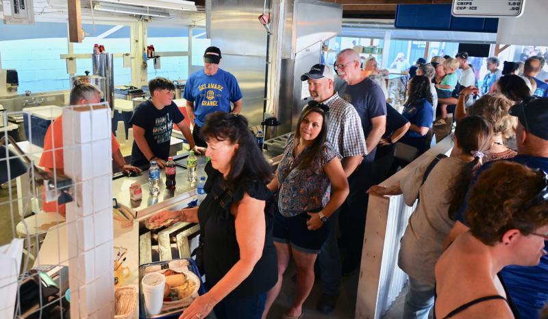 Volunteers take care of a long line of hungry customers at The Grange food stand, which has been a longtime fair tradition. The platters of chicken, corn, tomatoes and potato salad have stood the test of time and always taste good.