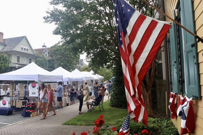 Old Glory flies at a historic house on Second Street as people visit vendors at the annual art show.