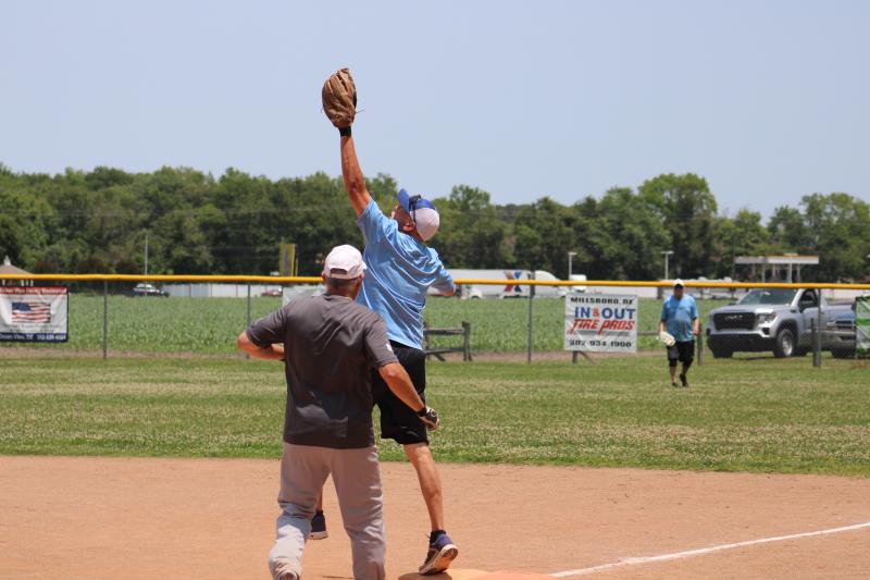 Edward Jones Investment’s Kerry Crouch reaches up to nab the final out of the game, hanging on to first by his toes. Edward Jones won 11-10 June 15.