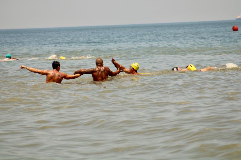 Two rescuers stand on shore as the victim is pulled in by the rescue swimmer in the body rescue event. Jake Pangle, front, and Demetrius Stevenson secure the handoff from rescue swimmer Santiago Ludwig to bring victim Matt Johnston ashore.