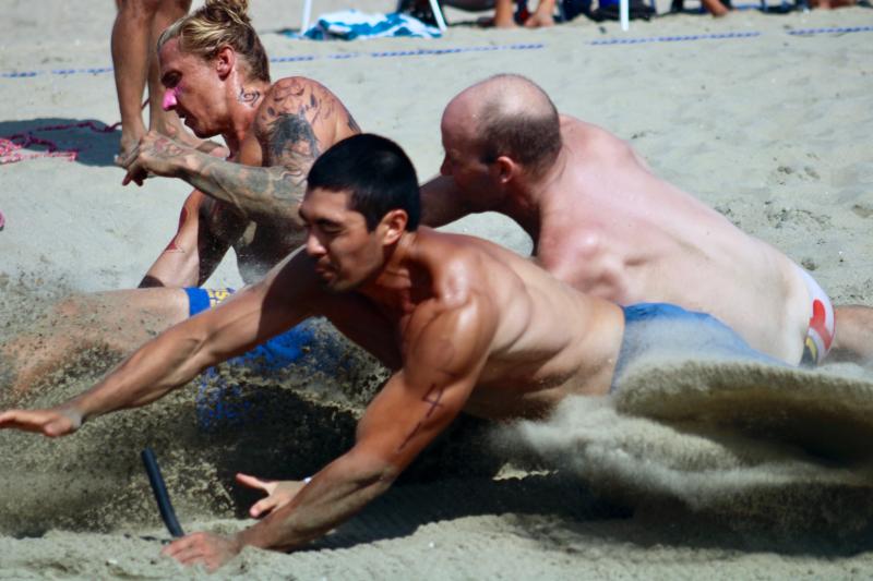 During the men's beach flags race, Dewey Beach Patrol’s Steve Hagen grabs a flag while Delaware Seashore State Park’s Nick “Panda” Peneranda, left, narrowly edges out Ocean City Beach Patrol’s Alex Hufnagel.