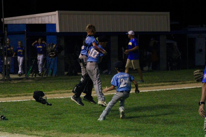 Lucca Fazio embraces his closer Ben DiMuzio as the winning pitcher Chase Sanchez joins in on the celebrations.