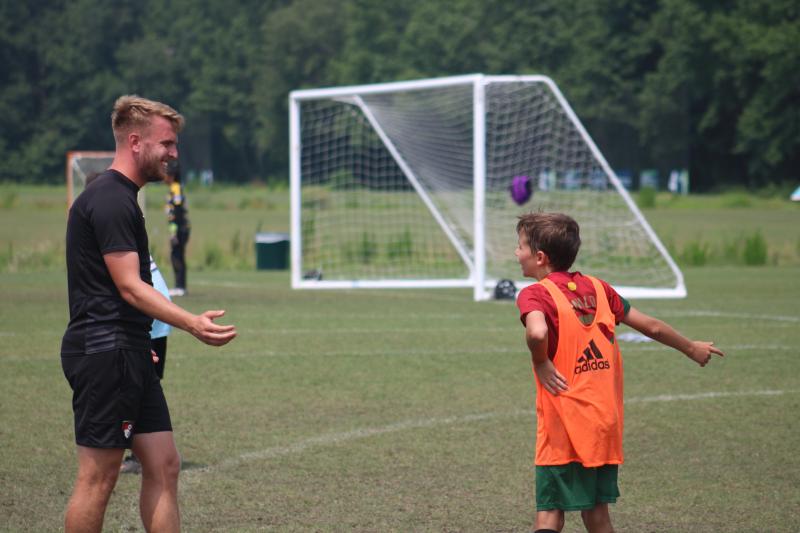 AFC Bournemouth trainer Ben Cooper talks to incoming Love Creek Elementary fifth-grader Eli Evans. Evans had just dribbled through nearly the entire defense and had a clear path to the goal. He chose to stop and dribble back into the defense, so Cooper was telling him he earned the right to take a shot and he should have taken it.