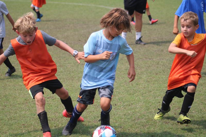 Incoming Lewes Elementary third-grader Adam Deyak was proud to tell his dad he scored a few goals on the day. In this shot, he shows off delicate footwork while dribbling past two well-positioned players.