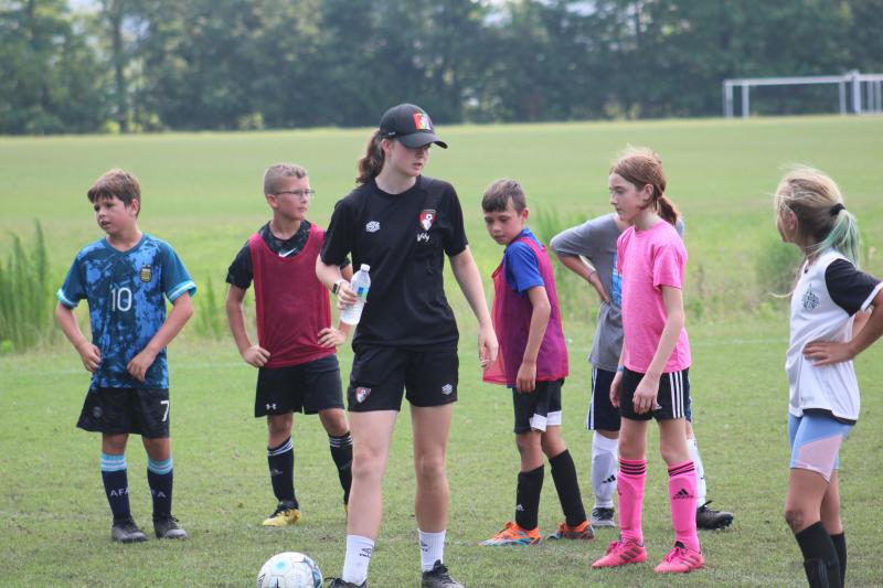 Ruth Topping, who played for AFC Bournemouth in the women’s Premier League Division One, organizes her players in preparation for a penalty kick that occurred as a result of a handball in the box.