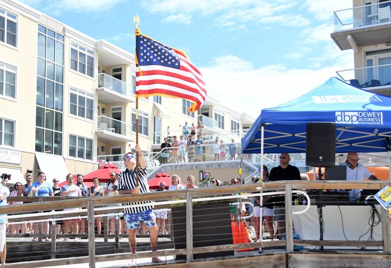 Dewey Business Partnership Vice President and Woody’s Dewey Beach owner Jimmy O’Conor raises the flag for the national anthem.