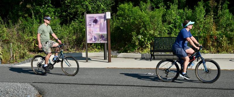 Two cyclists get in an early morning ride on the Lewes-to-Georgetown Trail as they approach the Nassau Road crossing.