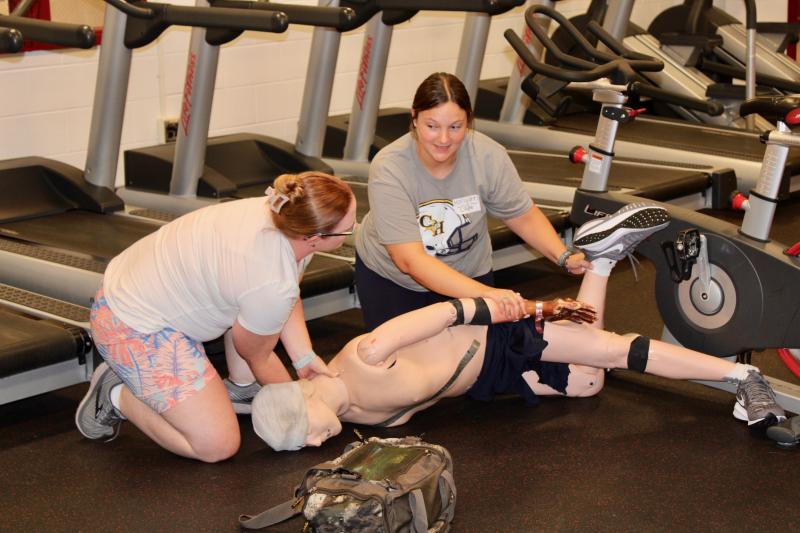 First State Orthopaedics and ATI trainer Taylor Duncan, left, is the trainer in this scenario. Cape Henlopen athletic trainer Hollyann Wettstein plays the role of an unskilled bystander who needs clear, concise instructions to help.