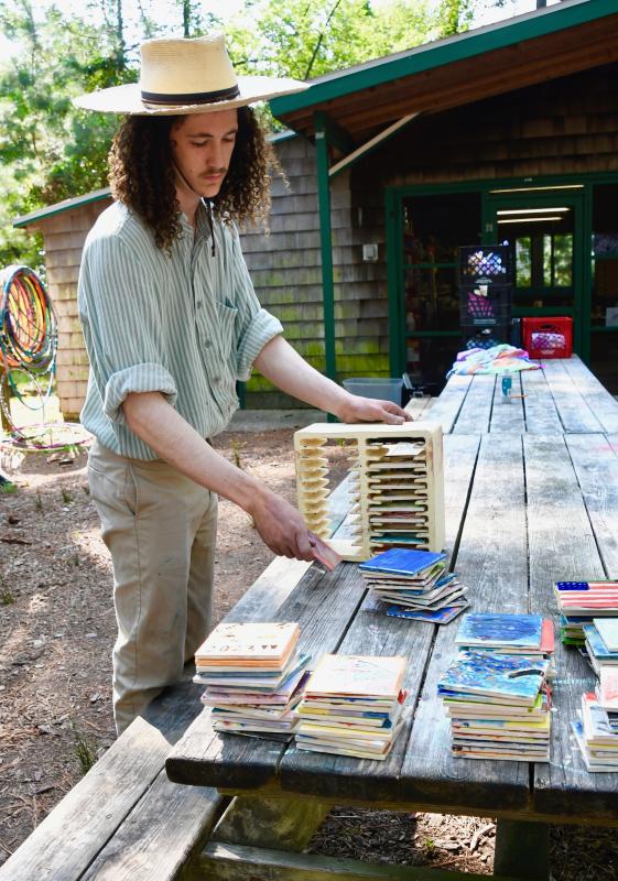Dennett Brown, camp arts and crafts shop director, removes tiles made by campers after they have been fired in the kiln.