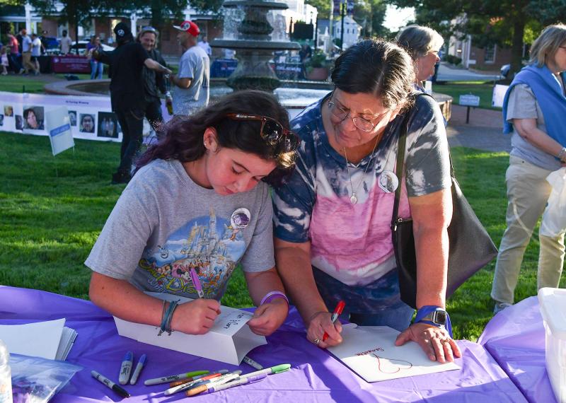 Aurora Palverento, 10, and her grandmother Teressa Payne make a paper bag luminary to honor loved ones lost to overdose.