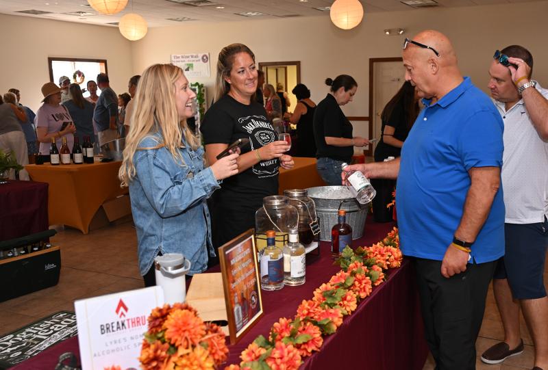 Brad Levin, right, gets a sample of Lyre’s Tequila from Break Thru Beverage Group’s Thyler Rutkoske and Jillian Funk.