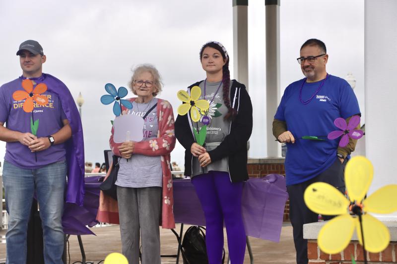 Walkers carry flowers of different colors to represent how they have been impacted by Alzheimer’s. Shown are (l-r) Cody Smith of sponsor Edward Jones; Doris Daisey, who is living with Alzheimer’s; her caregiver, Karson Barenholtz; and Dr. Tony Buonanno, Beebe Healthcare chief medical officer, representing someone who has lost a loved one to the disease.