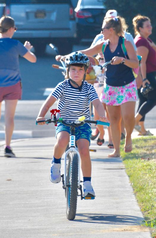 Lewes Elementary first-grader Sawyer McGowan rides his bike to school on the first day. He was joined by his sister, fourth-grader Maisie. RON MACARTHUR PHOTO