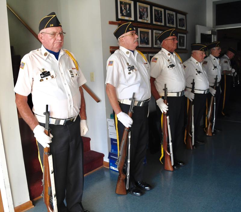 Members of American Legion Post 28 Honor Guard stand at attention prior to going outside for a gun salute.