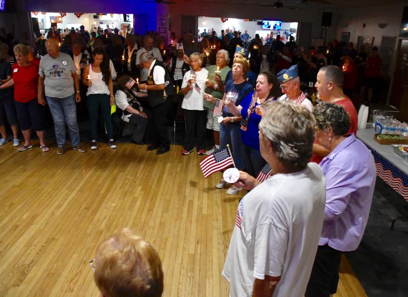 Attendees join hands in a circle and sing Lee Greenwood’s “God Bless the USA” to conclude the ceremony.