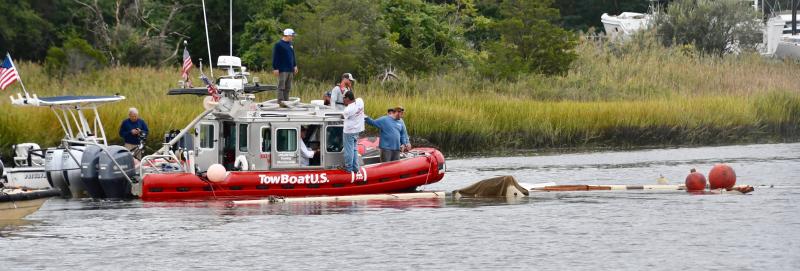 Part of the sailboat begins to float to the surface as crews work underwater and on boats to raise it. RON MACARTHUR PHOTO