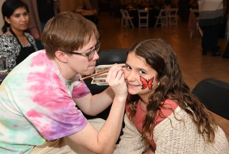 Perry Dickens, 10, gets her face painted by artist Leah Martin.