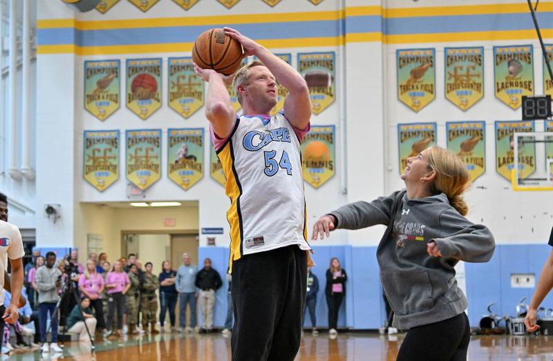 Macy Steinwedel, right, goes for the block on the shot of staff member Jason Fruchtman during the pep rally basketball game.