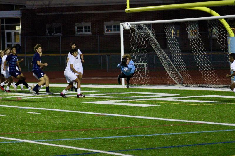 Seahawks junior goalkeeper Carter “C.J.” Norton dives and punches away a free kick from Vikings junior Cardin Benjamin.