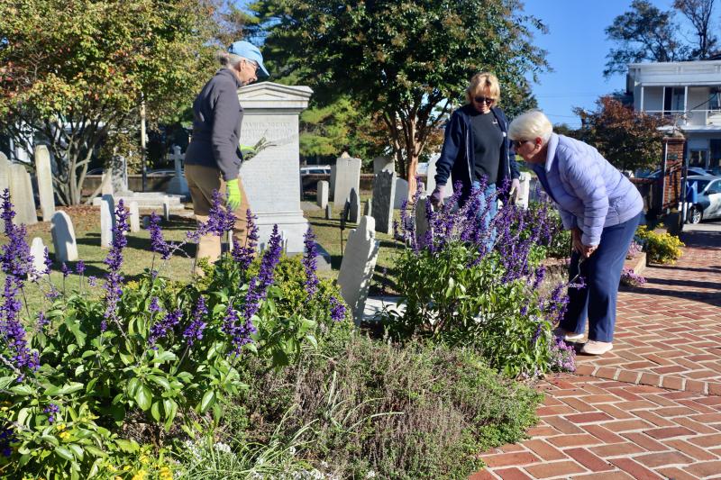 Volunteers Karen Fischer, Brenda Mitchell and Anne Broomfield pull weeds from the flowers at St. Peter’s.