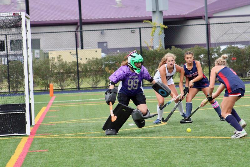 Seahawks sophomore Kacie Rawlings comes out of her cage to challenge Patriots junior Amanda Rattay. Sussex Academy sophomore Ava Yenovkian and Newark Charter Sophia Orlando prepare to react to the shot.