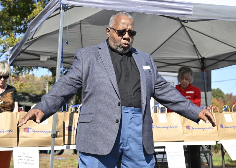 The Rev. Charles Gilmore of Coolspring Presbyterian Church blesses the offerings, residents and guests of the Springboard Pallet Village.