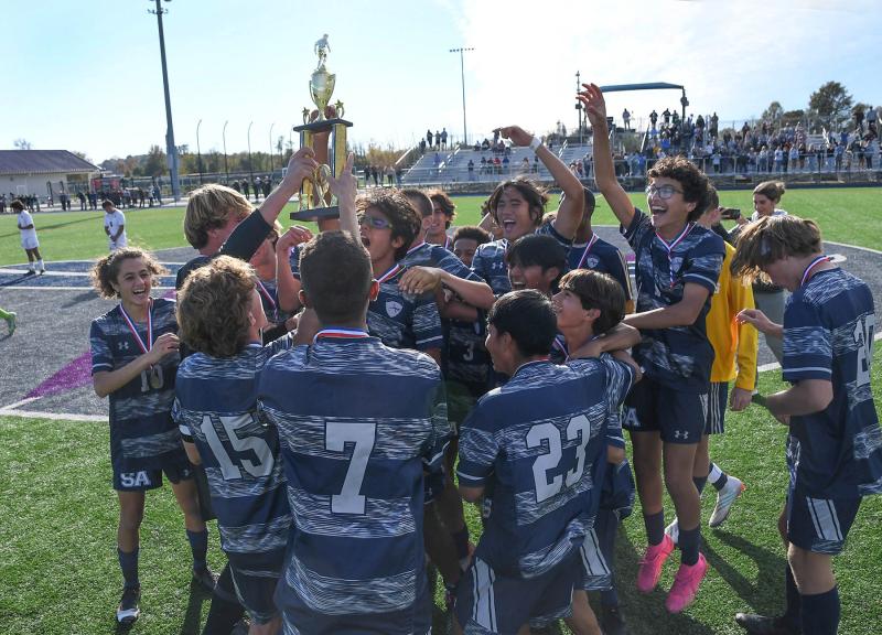 Sussex Academy junior captain CJ Norton hoists the Henlopen Conference Championship trophy after defeating the Sussex Central squad Nov. 4 in Georgetown.