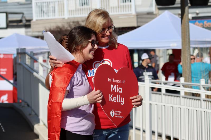 Mia Kelly receives a heart from this year’s Heart Walk Chair Cathy Bassett of Mountaire Farms. Kelly has survived 24 years after being born with a congenital heart defect.