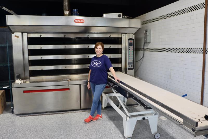 Anita Wheeler-Bezy stands in front of La Baguette’s new oven that is imported from Italy. She said it can bake 600 loaves an hour.