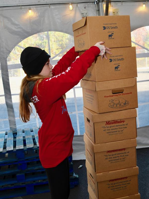 Cape Henlopen High School student Samantha Doyal reaches high to stack boxes at the start of an assembly line.