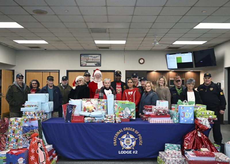 Members of the Fraternal Order of Police Lodge 2 stand behind gifts before they head out for delivery. Shown are (l-r) Michael Pantaze, Melanie Pantaze, Robert Doty, Dan Solow, Janet Petros, Al Weir, Santa Claus, Laurel Pastor, Greg Fuller, Tina Rivera, Sherman Littleton, Jerry Gibson, Terri Gibson, Dale Hammond, Steve Smyk Sr., Sandi Smyk and Robert J. Schappert III.