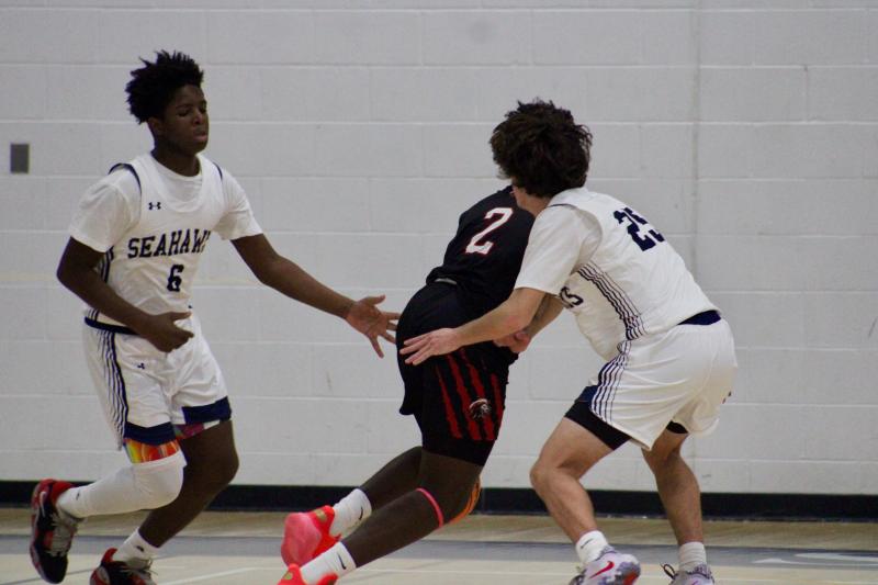 Sussex Academy freshman Sebastien Paul works a double team with sophomore Nate Elliott to force a turnover.