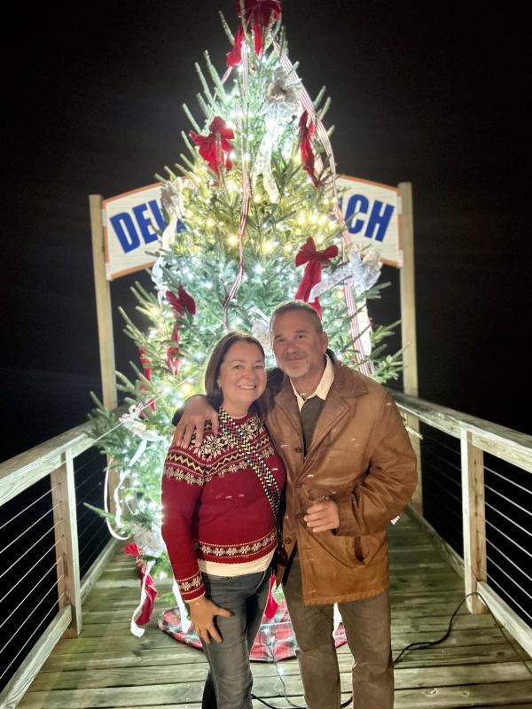 Dewey Beach Commissioner Elisabeth Gibbings and her husband David Marlowe gather in front of the tree on the TJ Redefer Memorial Baywalk.