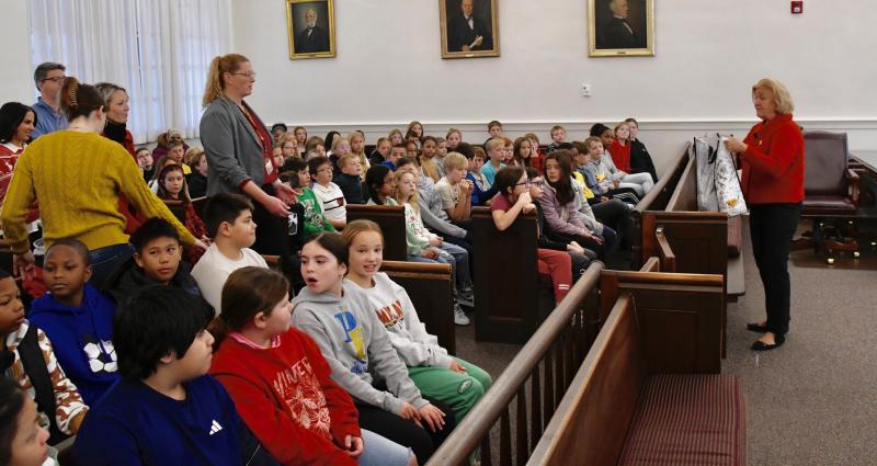 Jane Brady, who has been involved with the production since it started 20 years ago, instructs the audience of Love Creek Elementary School students when to ring their bells in support of Kris Kringle.