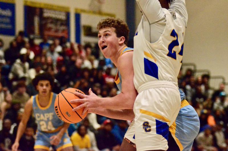 Vikings senior Jack Schell powers through Golden Knights senior Kyle Custis to get a clean look at the basket.