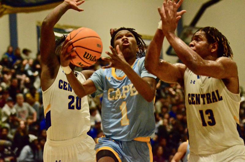 Cape freshman Geordan Downing, center, goes for a lay-up between Sussex Central junior Malik Bell, left, and senior Clarence McBride-Allen.